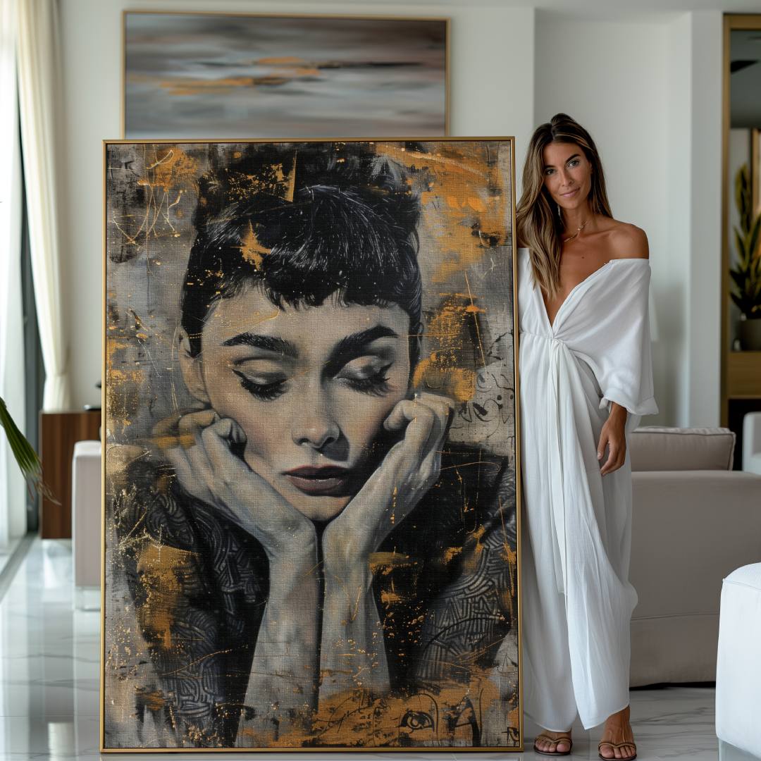 Donna accanto a stampa su tela moderna con ritratto di Audrey Hepburn, motivi lussuosi, colori oro argento e nero